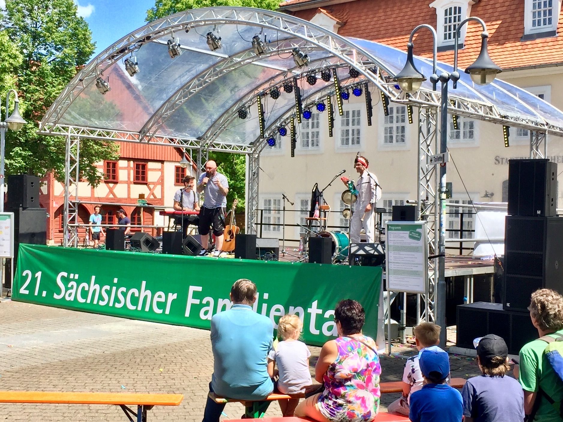 Überdachte Bühne auf einem Platz mit Publikum bei Tageslicht