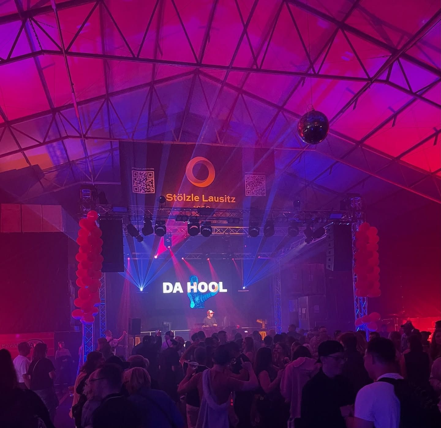 Sommerfest von Stölzle Lausitz 2025 im Hallenzelt: Traversen-Bühne mit LED-Wand, Moving Heads und Spiegelkugel, davor feiernde Gäste